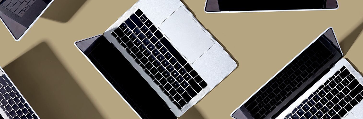 A collection of laptops open on a table.