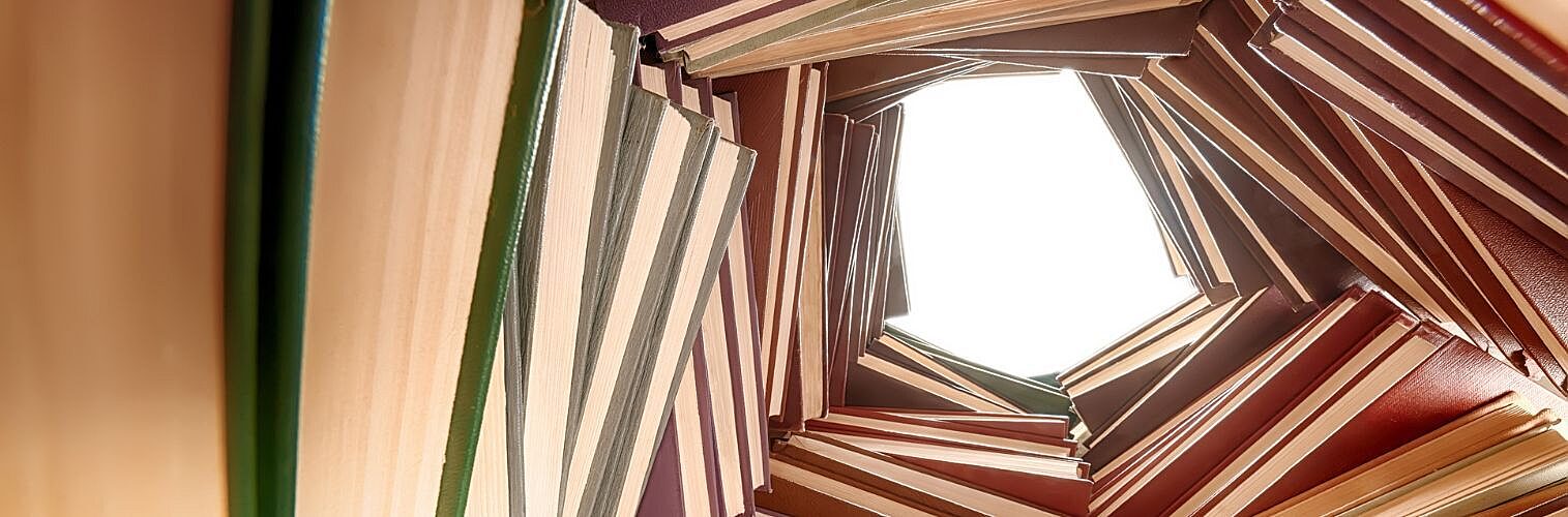 Large hardcover books in a pile.