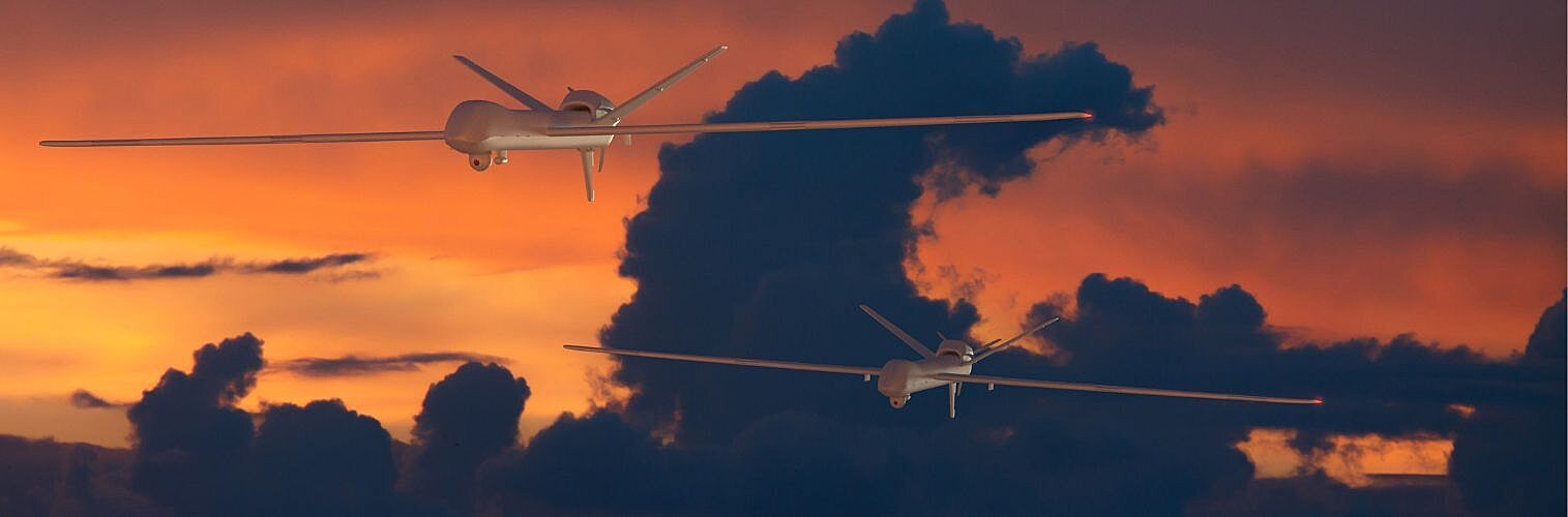 Drones flying against the sunset.