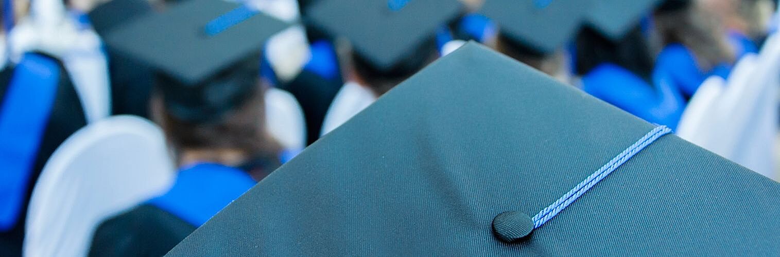 Proud students attend their graduation in mortarboards.
