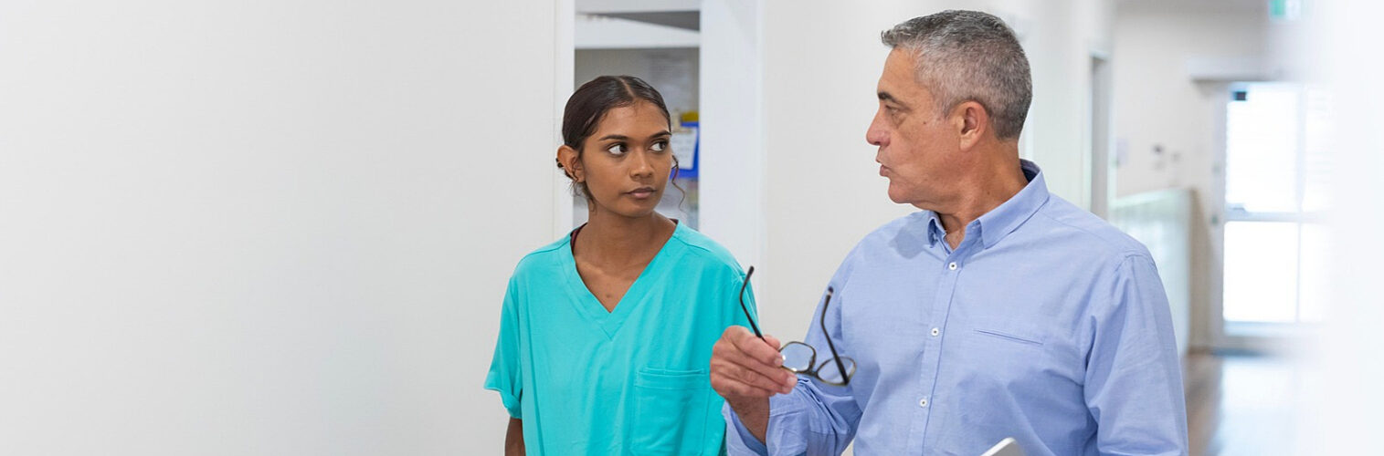 Aboriginal patient talking with doctor in hospital hallway.