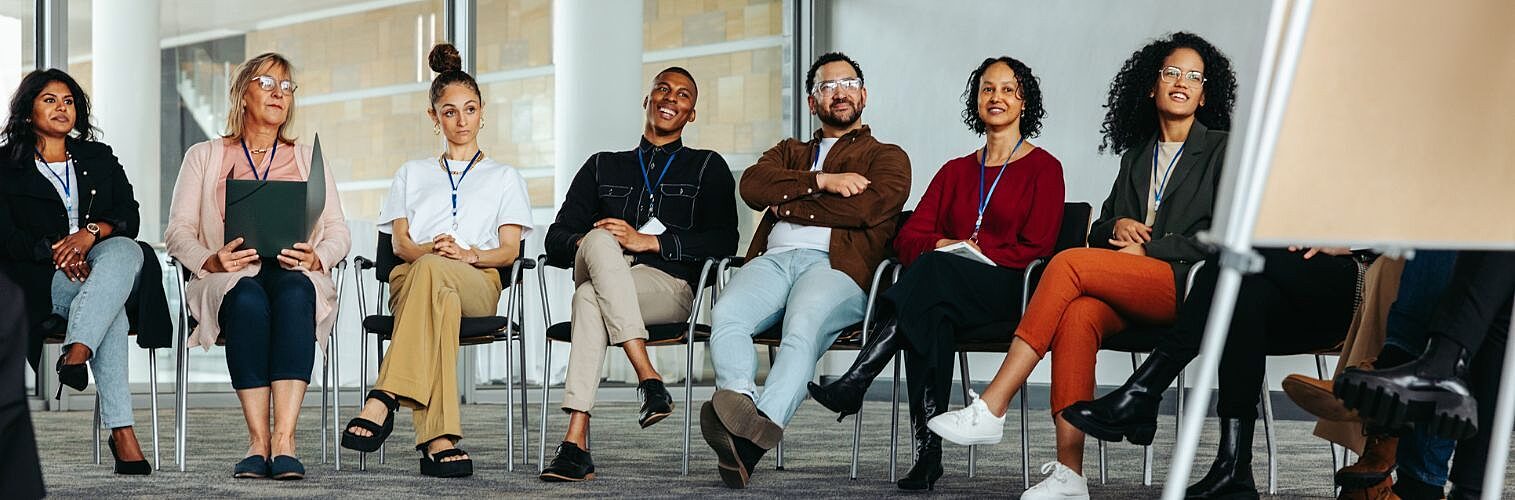 Diverse group of people at a business conference in a modern office.