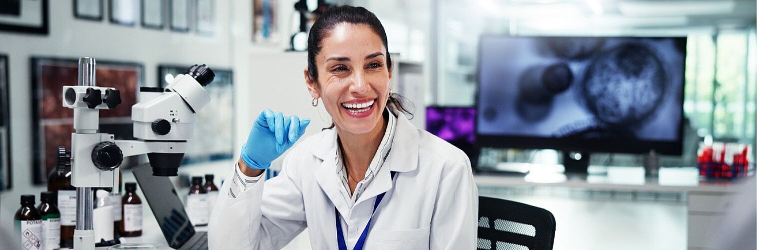 Research scientist smiling in a lab.
