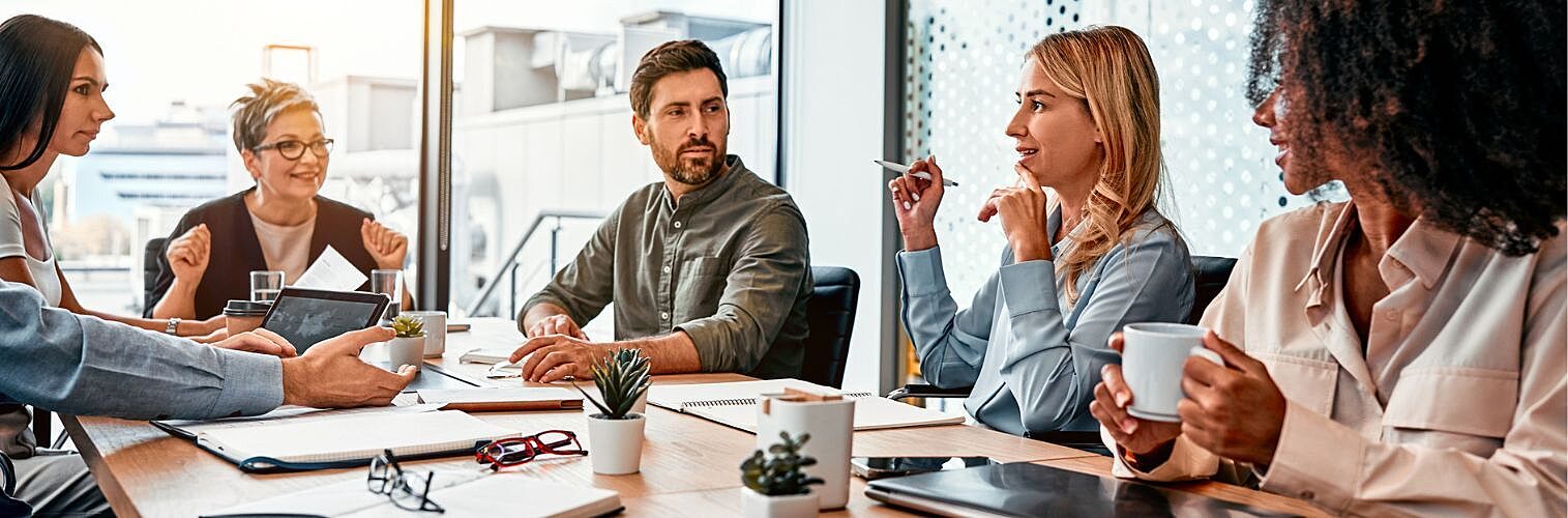 Businesspeople discussing at a table in a modern office.