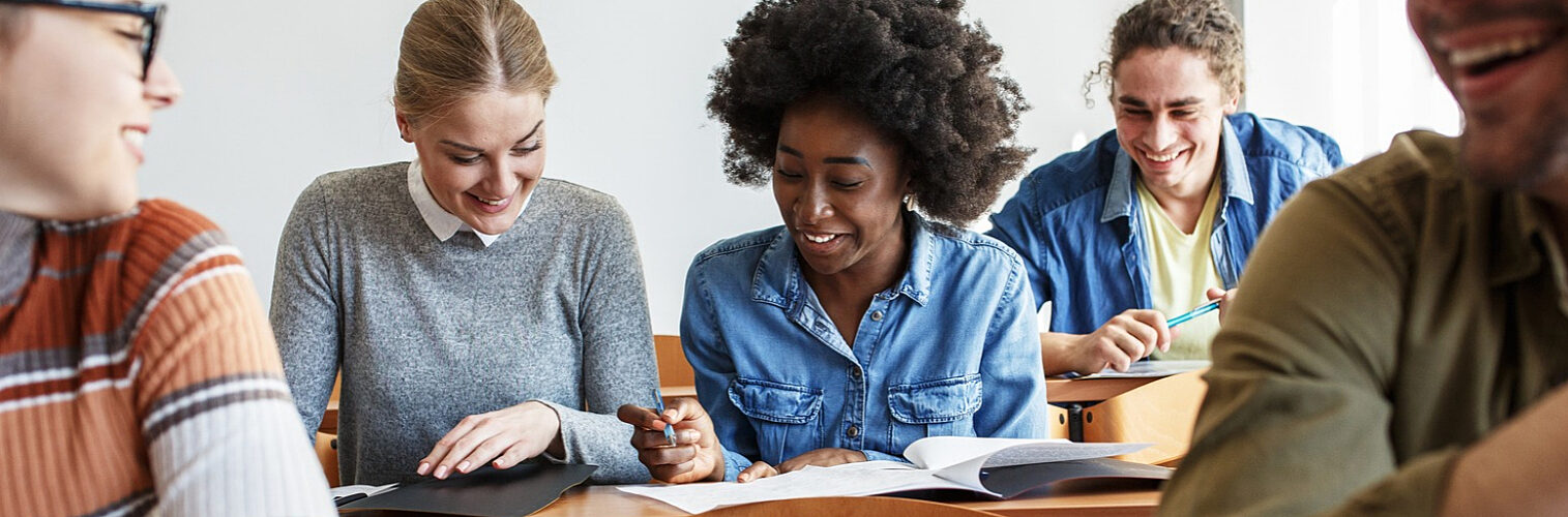 Group of college students taking a test in a classroom.