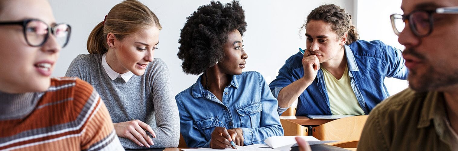 Group of university students taking a test in a classroom.