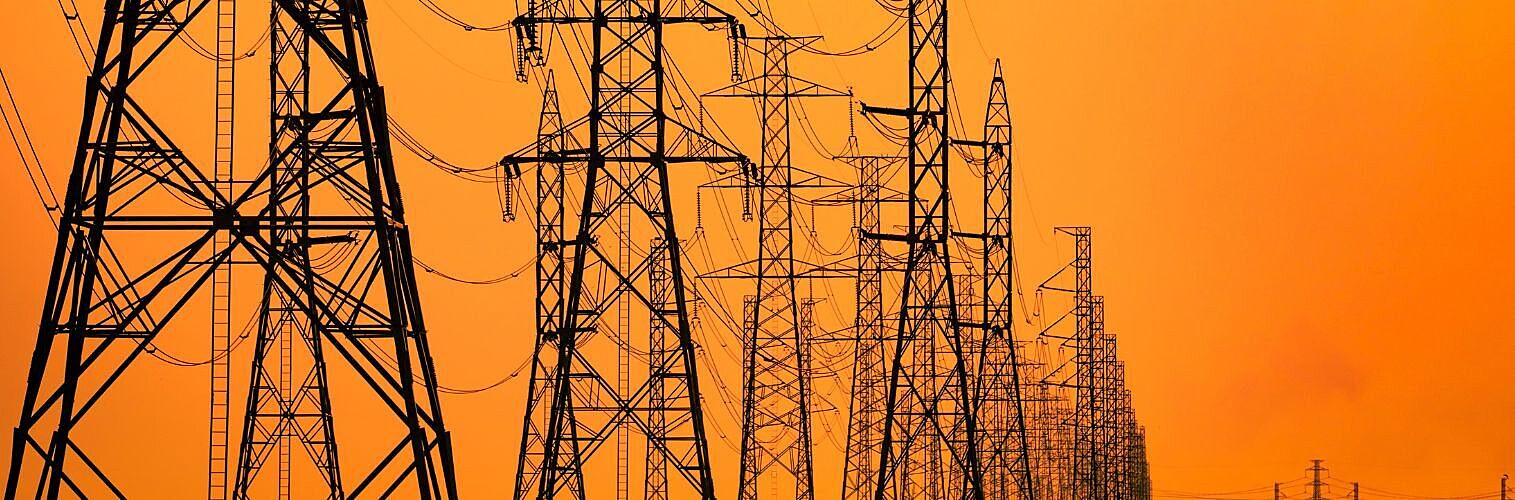 High voltage electric pole and transmission lines in the evening.