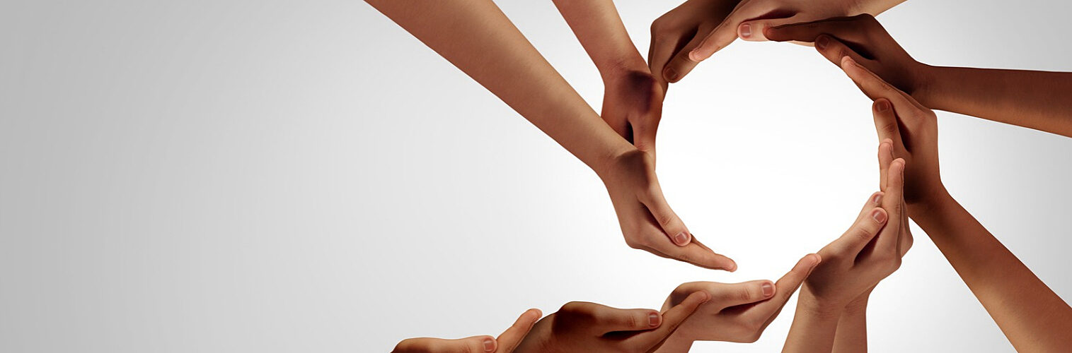 A diverse group of people forming a circle with their hands.