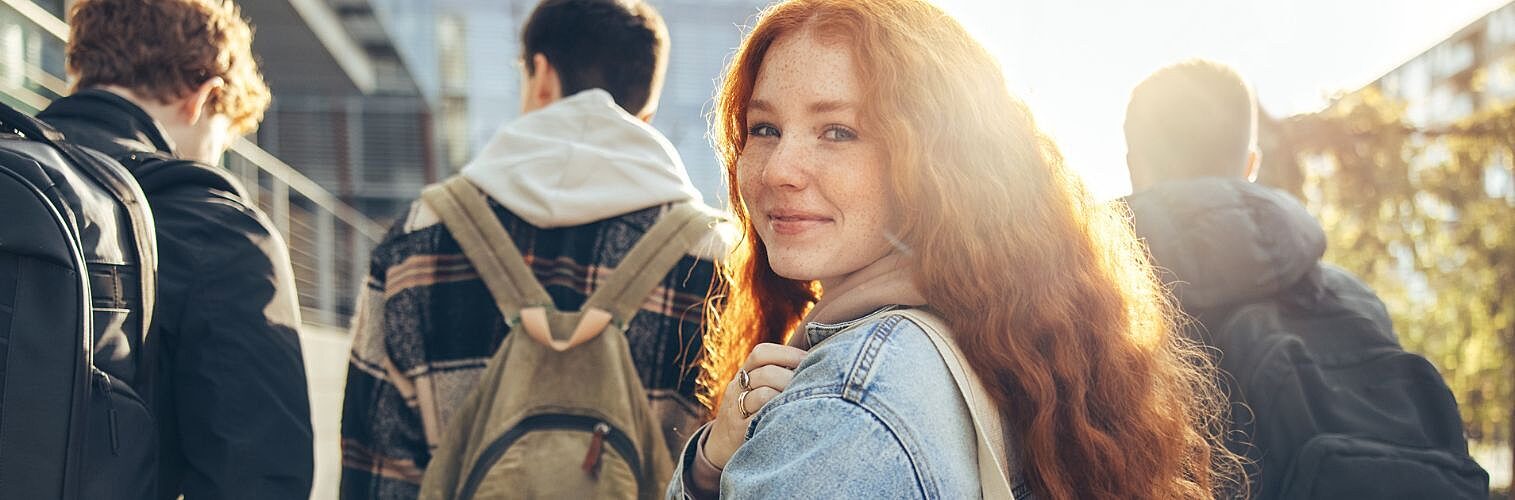 Female student glancing back while going for a class in college.