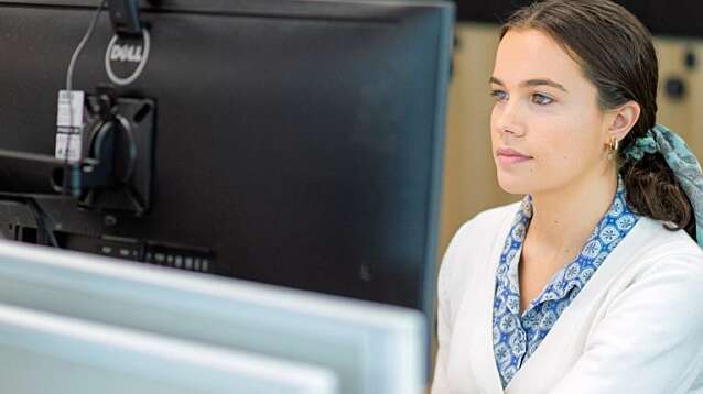 Close up of female Nouser working at a computer screen