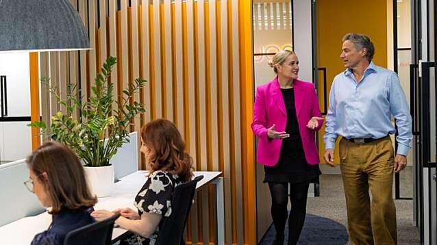 Nous staff collaborating in a modern, plant-filled office space.