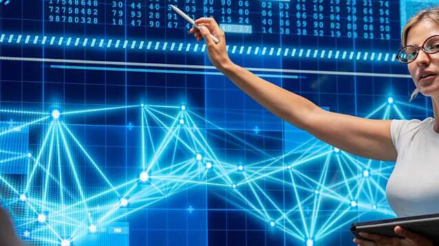 A female programmer confidently presents her investment analysis software to executives in a sleek office.