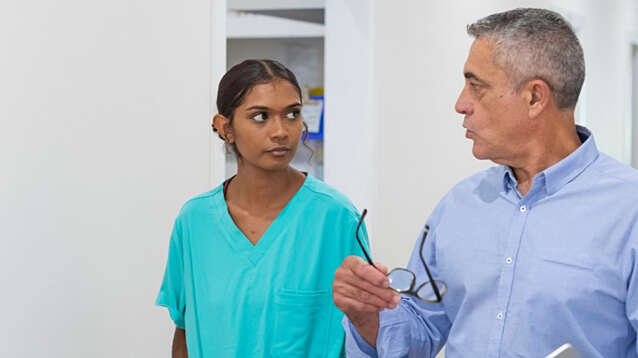 Aboriginal patient talking with doctor in hospital hallway.