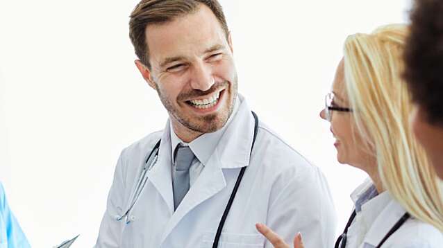 Portrait of a group of doctors and health care workers at meeting.