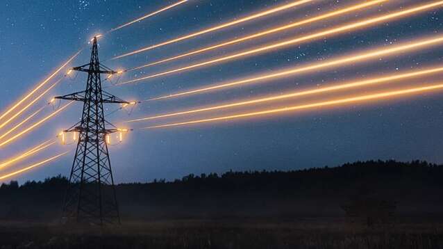 Electricity transmission towers with glowing orange wires.