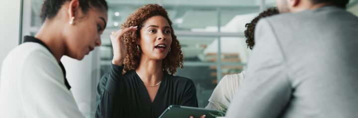 A woman at a meeting with her team.