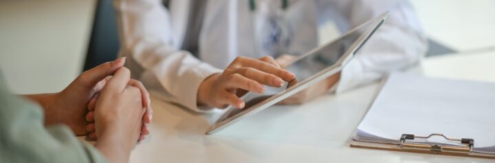 Shot of a doctor showing a patient some information on a digital tablet.