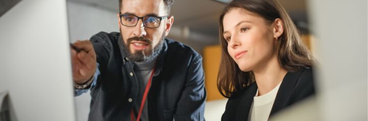 Lecturer helps a scholar with her project on a computer.