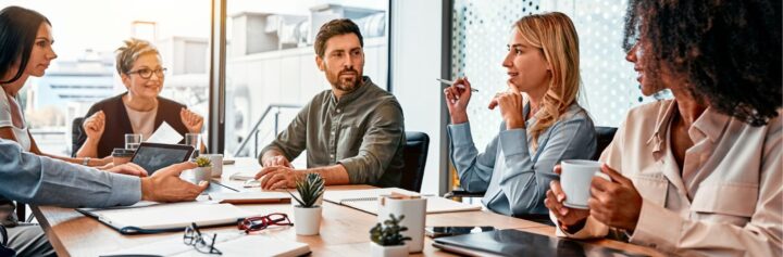 Businesspeople discussing at a table in a modern office.