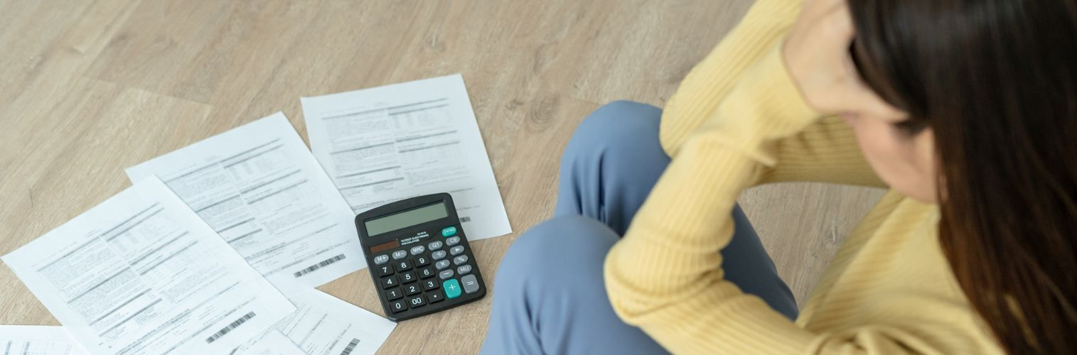Woman looking over bills with calculator