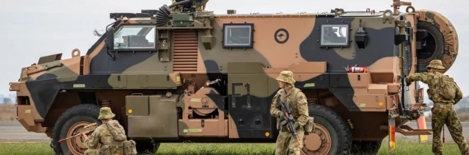Australian army soldiers next to armoured vehicle