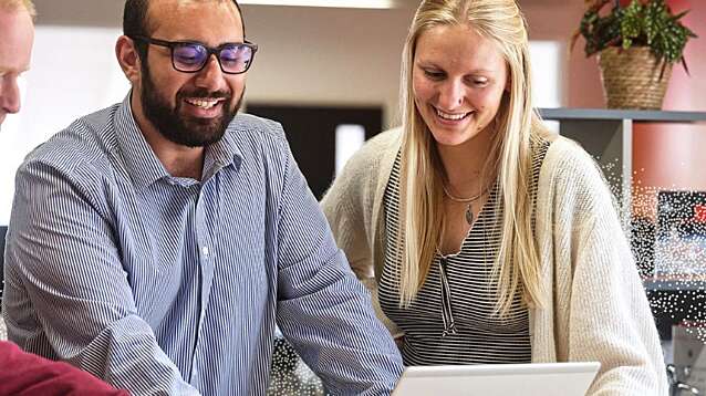 Three Nousers looking over a laptop