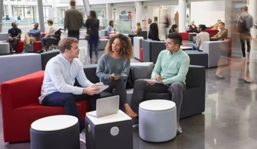 University students talking while sitting in a busy common area