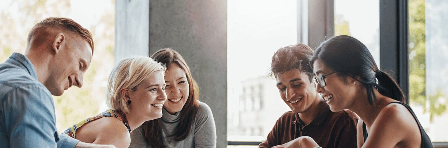 A small group of university students talking while sitting around a table