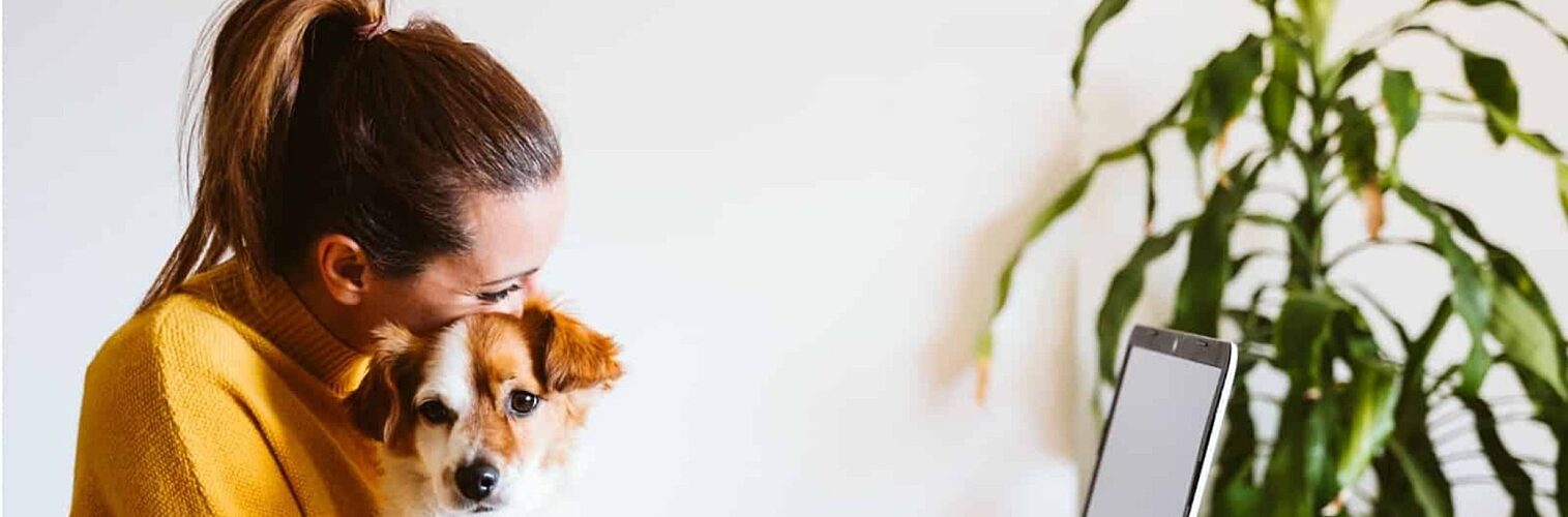 Woman working from home holding dog