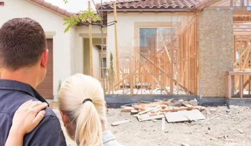 Man and woman looking at house that is getting built