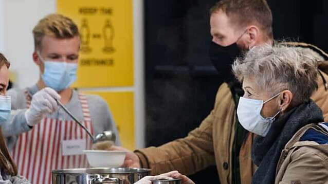 Volunteer handing over food at a soup kitchen